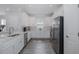 Modern kitchen with white cabinets, granite countertops, stainless steel appliances, and wood-look tile flooring at 3051 Francoa Dr, Odessa, FL 33556