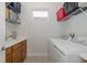 Bright laundry room with sink, washer, dryer, and overhead storage at 3051 Francoa Dr, Odessa, FL 33556