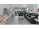 Bright living room with tile flooring, media center, and sliding glass doors that provide views of the pool and lanai at 3051 Francoa Dr, Odessa, FL 33556