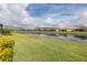 Picturesque view of a tranquil pond reflecting the blue sky, complemented by lush green grass and well-maintained landscaping at 3051 Francoa Dr, Odessa, FL 33556