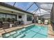 Screened-in pool with outdoor kitchen, seating, and landscaped yard at 3051 Francoa Dr, Odessa, FL 33556