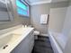 Clean bathroom featuring a quartz counter top, modern vanity, and a bathtub with tiled shower at 3304 Honeymoon Ln, Holiday, FL 34691