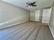A spacious bedroom with neutral walls, carpet, and a ceiling fan at 3304 Honeymoon Ln, Holiday, FL 34691