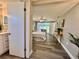 Light filled bedroom leading to the bathroom with wood-look flooring at 3304 Honeymoon Ln, Holiday, FL 34691