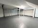 Spacious two-car garage featuring epoxy flooring, ample lighting, and overhead storage racks at 3304 Honeymoon Ln, Holiday, FL 34691