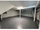 Spacious garage with epoxy flooring, featuring overhead lighting and door to enter into the home at 3304 Honeymoon Ln, Holiday, FL 34691
