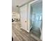 Hallway leading to an open-concept living room with wood-look flooring at 3304 Honeymoon Ln, Holiday, FL 34691