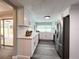 Updated kitchen featuring stainless steel fridge, white cabinets, and sliding glass doors to patio at 3304 Honeymoon Ln, Holiday, FL 34691