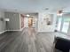 Open living space with white built-ins, exposed brick wall, and a view of the pool through French doors at 3304 Honeymoon Ln, Holiday, FL 34691