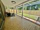 Screened-in patio with tile flooring, a comfortable chair, and a view of the backyard, ideal for relaxation at 3304 Honeymoon Ln, Holiday, FL 34691