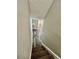 A stairway leading down into the home with carpet steps and wood-look flooring at the bottom at 3304 Honeymoon Ln, Holiday, FL 34691