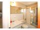 Bright bathroom featuring a shower-tub combo with sliding glass doors, a sink, and a toilet at 3851 Redwood Dr, Holiday, FL 34691