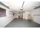 Spacious garage area featuring a garage door, grey floor, shelves, a sink and windows for natural light at 3851 Redwood Dr, Holiday, FL 34691
