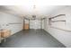 Spacious garage area featuring a garage door, grey floor, shelves, a sink and windows for natural light at 3851 Redwood Dr, Holiday, FL 34691