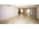 Spacious living room featuring light-colored flooring, white walls, and decorative barn door access at 3851 Redwood Dr, Holiday, FL 34691