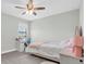 Bright bedroom featuring neutral walls, a ceiling fan, a bed set with a writing desk and a furry rug at 4056 Burdick Loop, Odessa, FL 33556