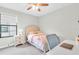 Bright bedroom featuring neutral walls, a ceiling fan, and a charming bed set with a writing desk at 4056 Burdick Loop, Odessa, FL 33556