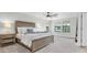 Primary bedroom features a large bed, bedside table and lamp with multiple windows for ample natural light at 4056 Burdick Loop, Odessa, FL 33556