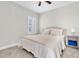 A serene bedroom with neutral tones, a ceiling fan, carpet flooring, and natural light at 4056 Burdick Loop, Odessa, FL 33556