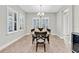 Well-lit dining room with plantation shutters, modern chandelier, and a table with seating for six at 4056 Burdick Loop, Odessa, FL 33556