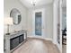 Inviting entryway with decorative door, stylish console table, round mirror, and wood-look flooring at 4056 Burdick Loop, Odessa, FL 33556