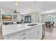 Kitchen island with marble countertops, modern sink fixture and cabinets, and living and dining areas nearby at 4056 Burdick Loop, Odessa, FL 33556