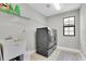 Clean laundry room equipped with modern washer and dryer, utility sink, and ample shelving at 4056 Burdick Loop, Odessa, FL 33556