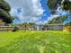 Beautiful backyard with lush lawn, mature trees, grill, and outdoor dining area at 4057 67Th N Ave, Pinellas Park, FL 33781