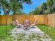 Outdoor dining area with a table and chairs, surrounded by a well-maintained lawn and fence at 4057 67Th N Ave, Pinellas Park, FL 33781