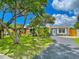 Charming home with a well-manicured lawn, lush landscaping, and a freshly paved driveway at 4057 67Th N Ave, Pinellas Park, FL 33781