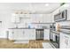 Bright kitchen with white cabinets, stainless steel appliances and wood-look floors at 4057 67Th N Ave, Pinellas Park, FL 33781