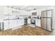 Modern kitchen features white cabinets, stainless steel appliances, and wood-look flooring at 4057 67Th N Ave, Pinellas Park, FL 33781