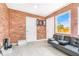 Bonus room features exposed brick walls, tile flooring, and a modern black futon sofa at 4057 67Th N Ave, Pinellas Park, FL 33781