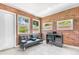 Cozy room with exposed brick, a sofa, desk, and multiple windows for natural light at 4057 67Th N Ave, Pinellas Park, FL 33781