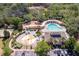 Aerial view of community pool and play area, surrounded by trees and parking, offering Gathering fun at 4094 Braemere Dr, Spring Hill, FL 34609