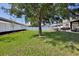 Expansive backyard showcasing a well maintained lawn, mature tree and white fence for privacy at 4094 Braemere Dr, Spring Hill, FL 34609
