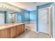 Bright blue bathroom featuring double sinks, a soaking tub, and a glass-enclosed shower at 4094 Braemere Dr, Spring Hill, FL 34609