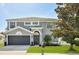 Charming two-story home featuring a manicured lawn, attached two car garage, and gray exterior paint at 4094 Braemere Dr, Spring Hill, FL 34609