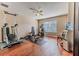 Brightly lit home gym featuring wood flooring, exercise equipment and a ceiling fan at 4094 Braemere Dr, Spring Hill, FL 34609