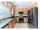 Kitchen featuring stainless steel appliances, wooden cabinets, granite countertops, and a kitchen window at 4094 Braemere Dr, Spring Hill, FL 34609