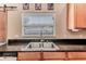 Kitchen sink with granite countertops, wooden cabinets, stainless steel appliances, and a view from the kitchen window at 4094 Braemere Dr, Spring Hill, FL 34609
