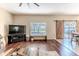 Open-concept living room with hardwood floors and sliding doors leading to an outdoor seating area at 4094 Braemere Dr, Spring Hill, FL 34609