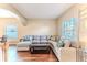 Spacious living room with hardwood floors, large sectional couch, and plentiful natural light at 4094 Braemere Dr, Spring Hill, FL 34609
