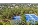 Aerial view of the community tennis and basketball courts with lush trees surrounding the area at 4094 Braemere Dr, Spring Hill, FL 34609