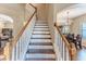 Elegant staircase with white risers and wooden handrail, connecting to the dining room at 4094 Braemere Dr, Spring Hill, FL 34609