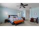A light blue bedroom featuring a king bed, ceiling fan, and a cozy sitting area with a window at 4215 Maplehurst Way, Spring Hill, FL 34609