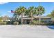 Community clubhouse with palm trees, American flag, ample parking, and manicured landscaping at 4215 Maplehurst Way, Spring Hill, FL 34609