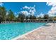 Expansive community pool offering plenty of space for swimming and leisure activities with lounge seating surrounding at 4215 Maplehurst Way, Spring Hill, FL 34609