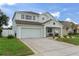 Beautiful two-story home with a two car garage, a inviting porch, and green landscaping at 4215 Maplehurst Way, Spring Hill, FL 34609