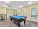 Well-lit game room with a blue pool table and comfortable seating, ideal for leisure and entertainment at 4215 Maplehurst Way, Spring Hill, FL 34609